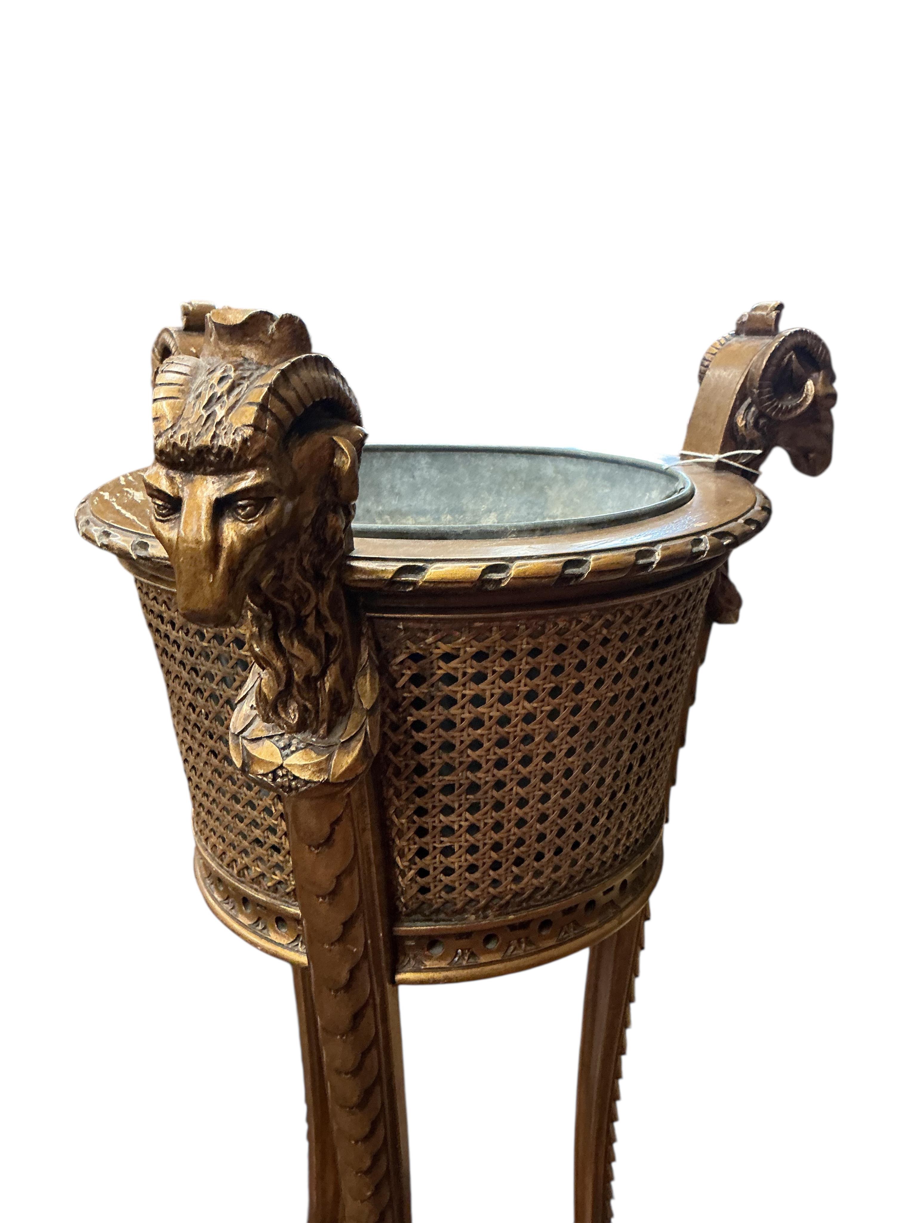 A Victorian style caned giltwood jardiniere with ram's head finials, height 99cm